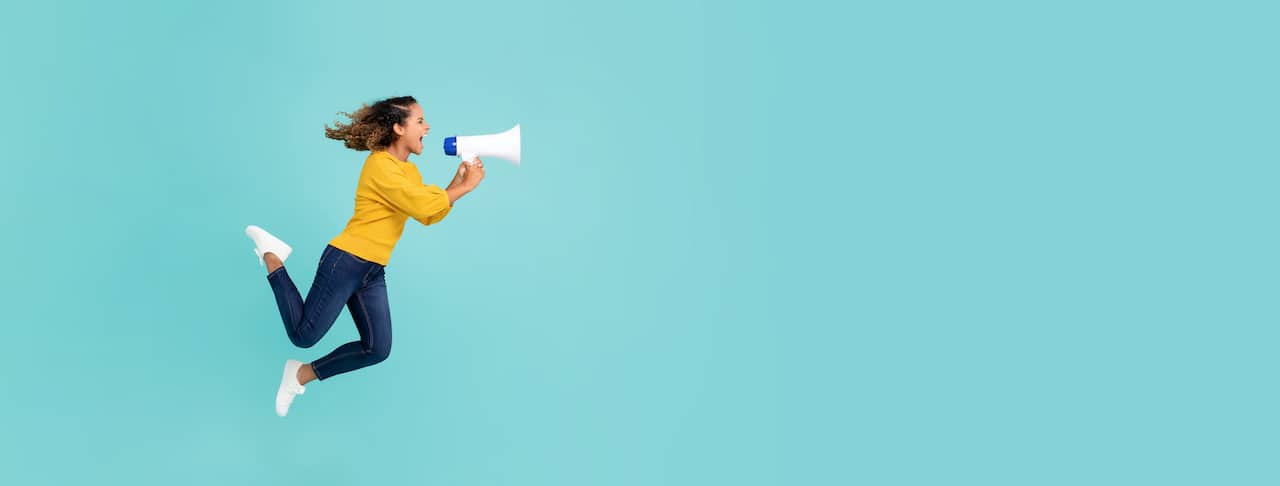 Girl with megaphone jumping and shouting
